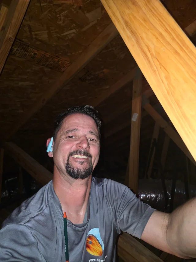 Jason smiling while working in an attic